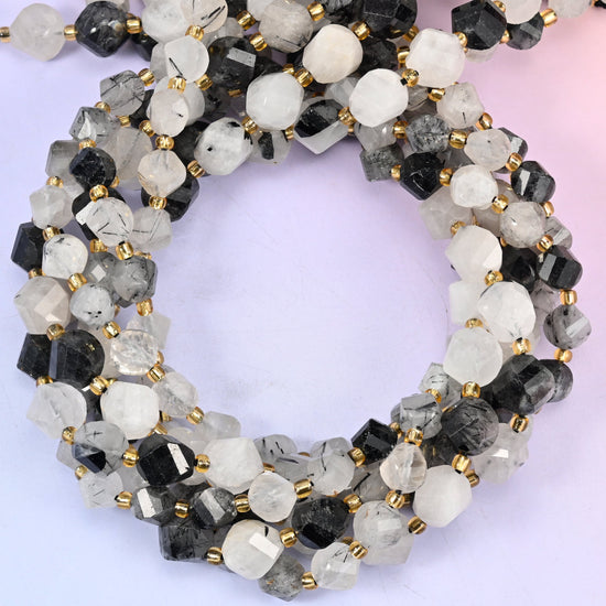 Black Rutilated Quartz faceted spiral twist beads, close view of the coiled strands showing milky white quartz with black needle inclusions