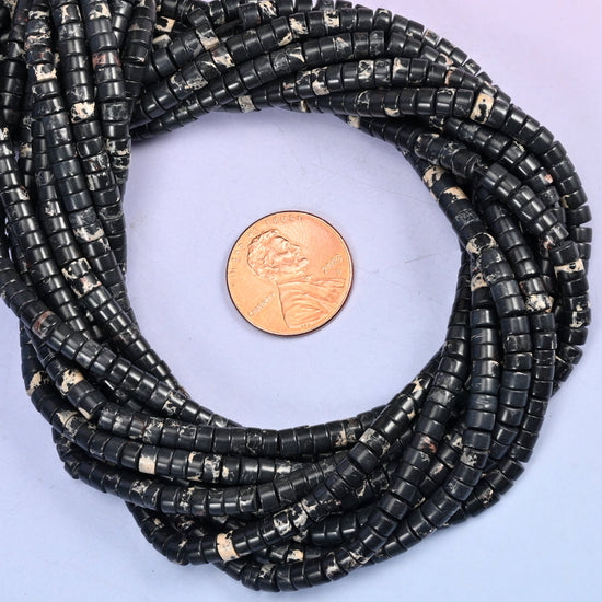 Black Sea Sediment Jasper smooth heishi disc bead strands coiled around a US penny for size reference