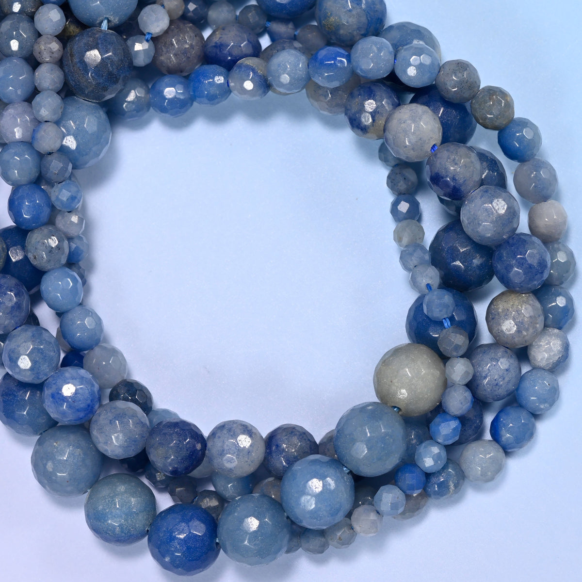 Blue Aventurine faceted round beads, close view of the coiled strands showing denim and pale blue