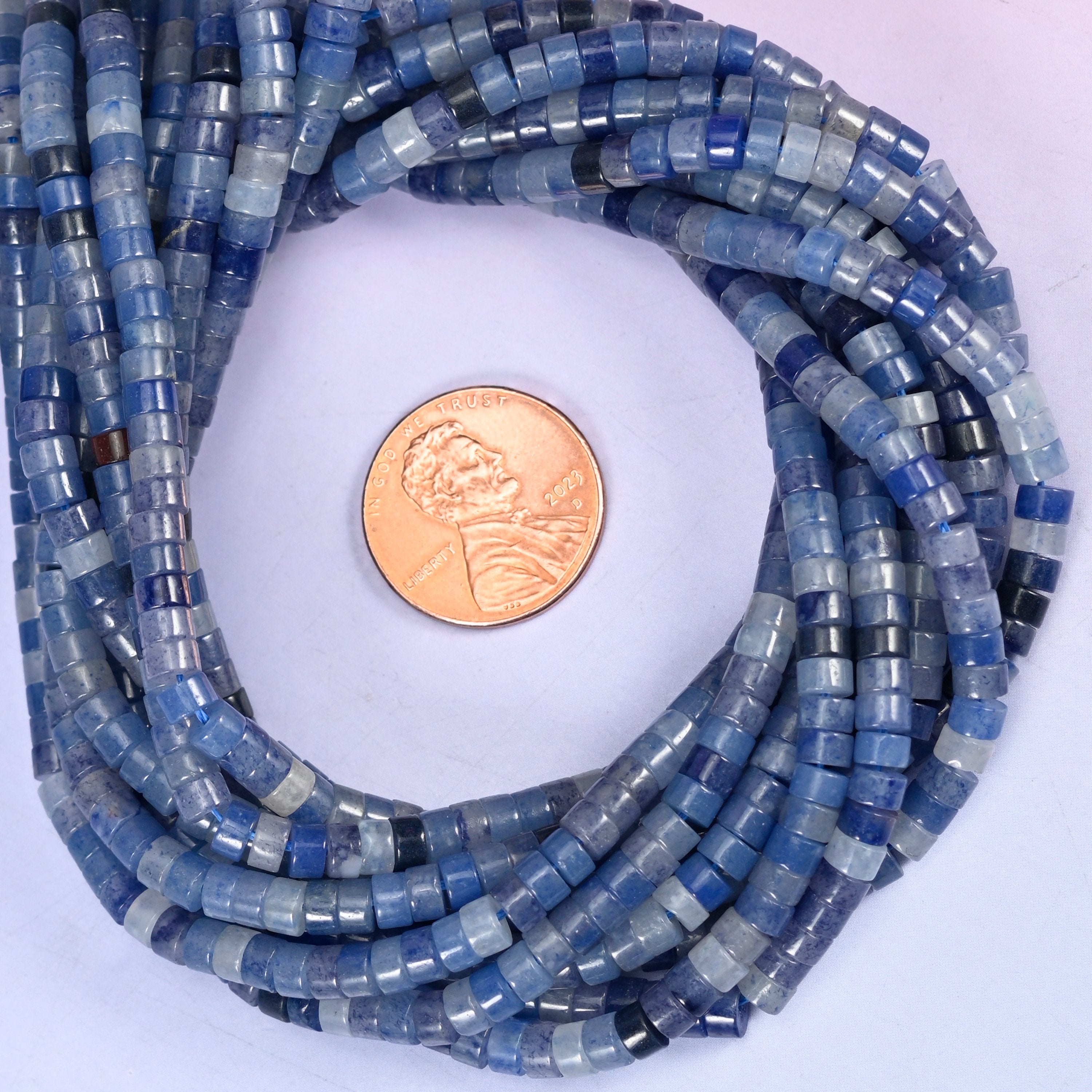Blue Aventurine smooth heishi disc bead strands coiled around a US penny for size reference