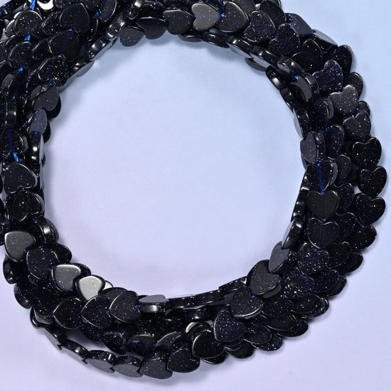 Blue Sandstone flat heart beads, close view of the coiled strands in near-black navy flecked with glitter