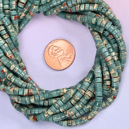 Blue Sea Sediment Imperial Jasper smooth heishi disc bead strands coiled around a US penny for size reference