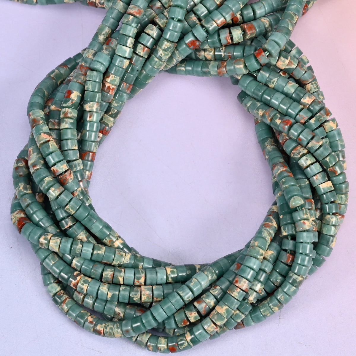 Blue Sea Sediment Imperial Jasper smooth heishi disc beads, close view of the coiled strands showing teal green with rust and cream matrix
