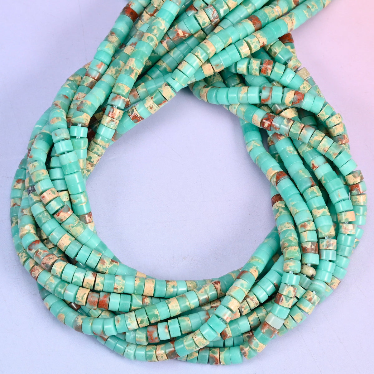 Blue Shoushan Stone smooth heishi disc beads, close view of the coiled strands showing turquoise green with tan and rust matrix