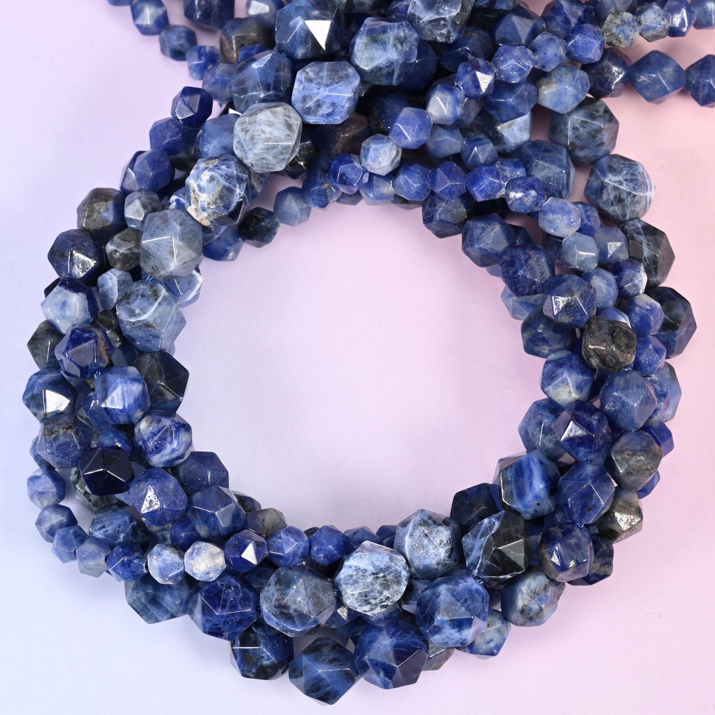Blue sodalite diamond star cut beads, several strands coiled into a loop.