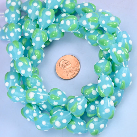 Blue White Dots Strawberry glass bead strands coiled around a US penny for size reference