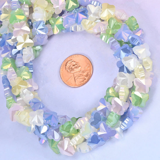 Butterfly glass bead strands coiled around a US penny for size reference