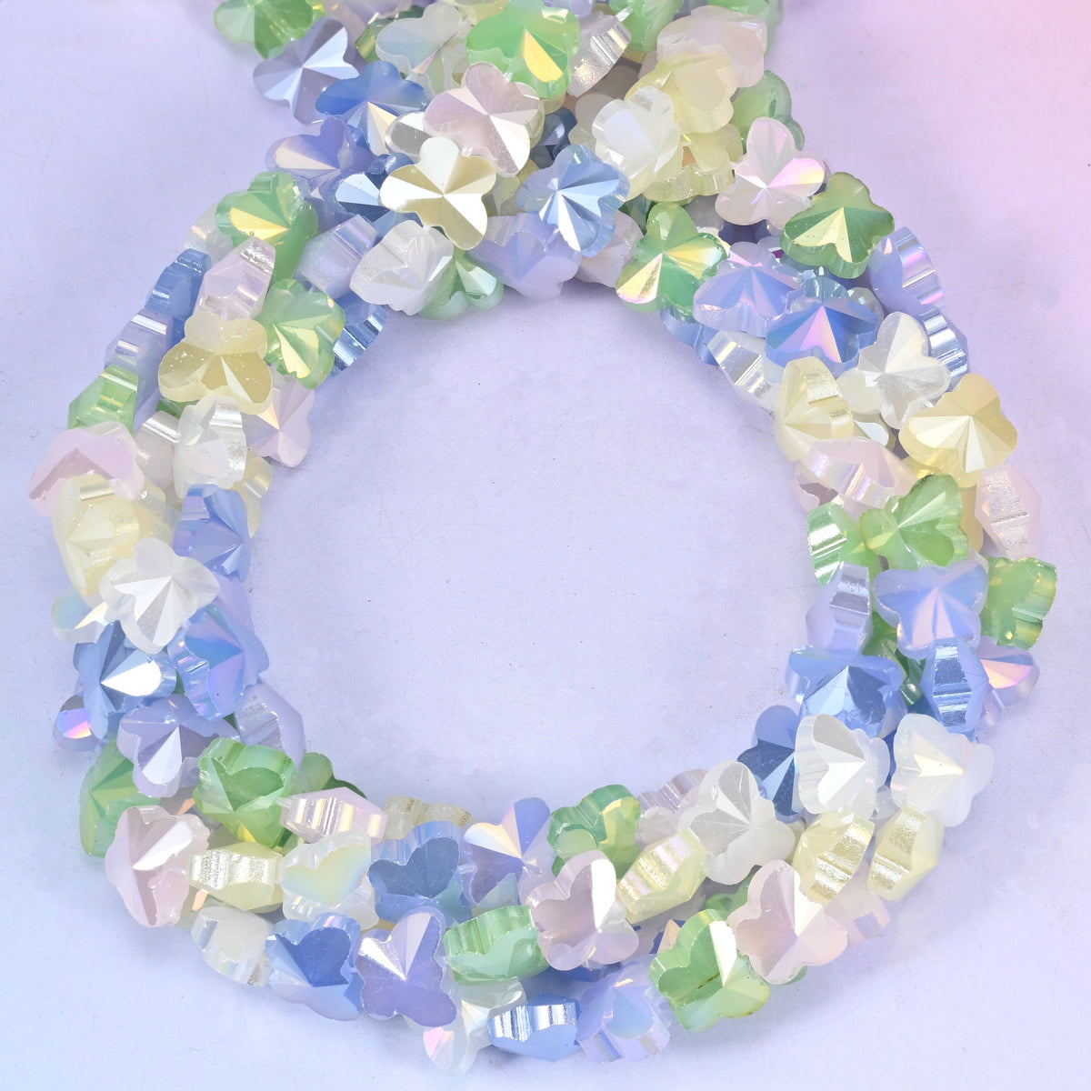 Butterfly glass beads, close view of the coiled strands mixing pastel blue, green, lilac and cream