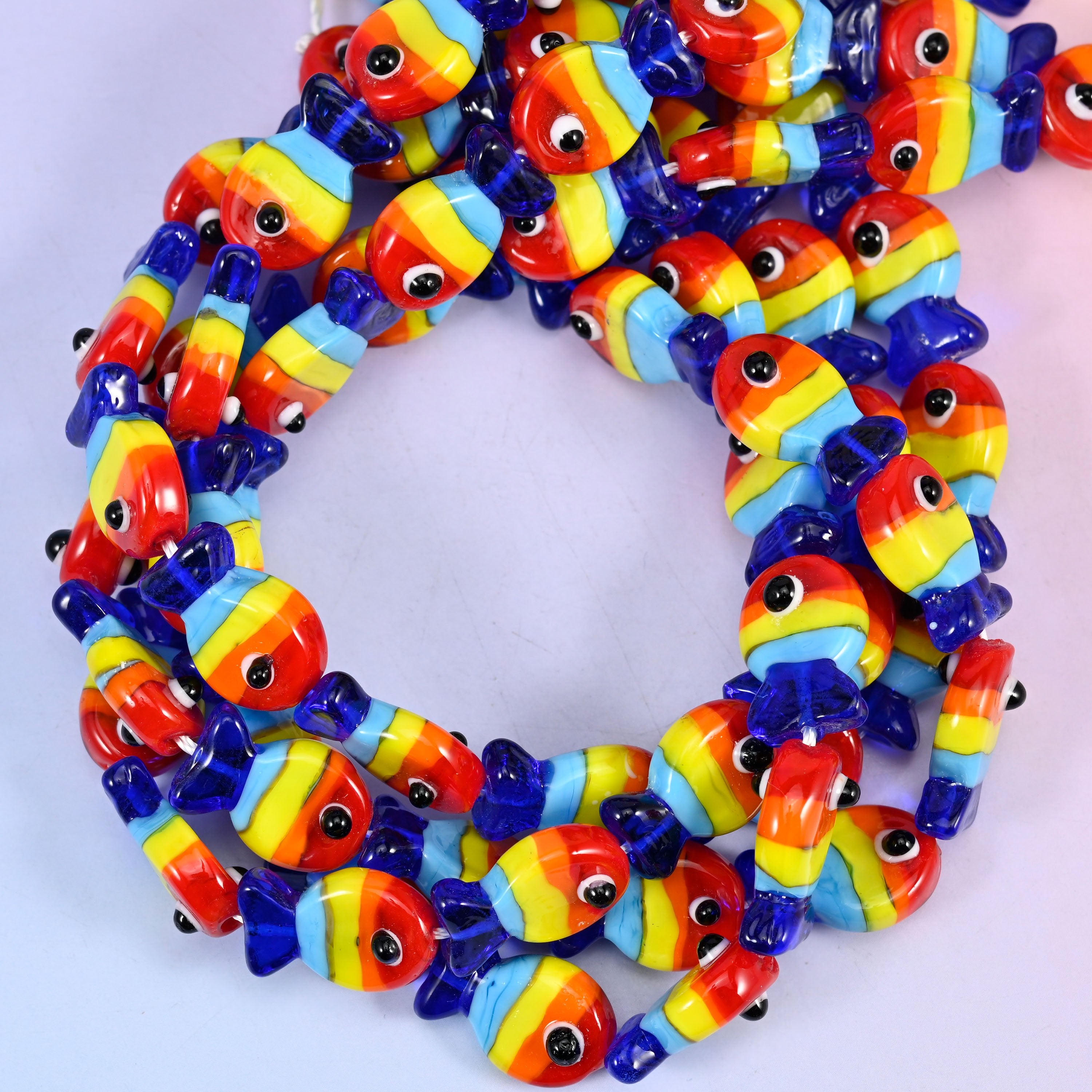 Colorful Fish glass beads, close view of the coiled strands striped in red, orange, yellow and blue