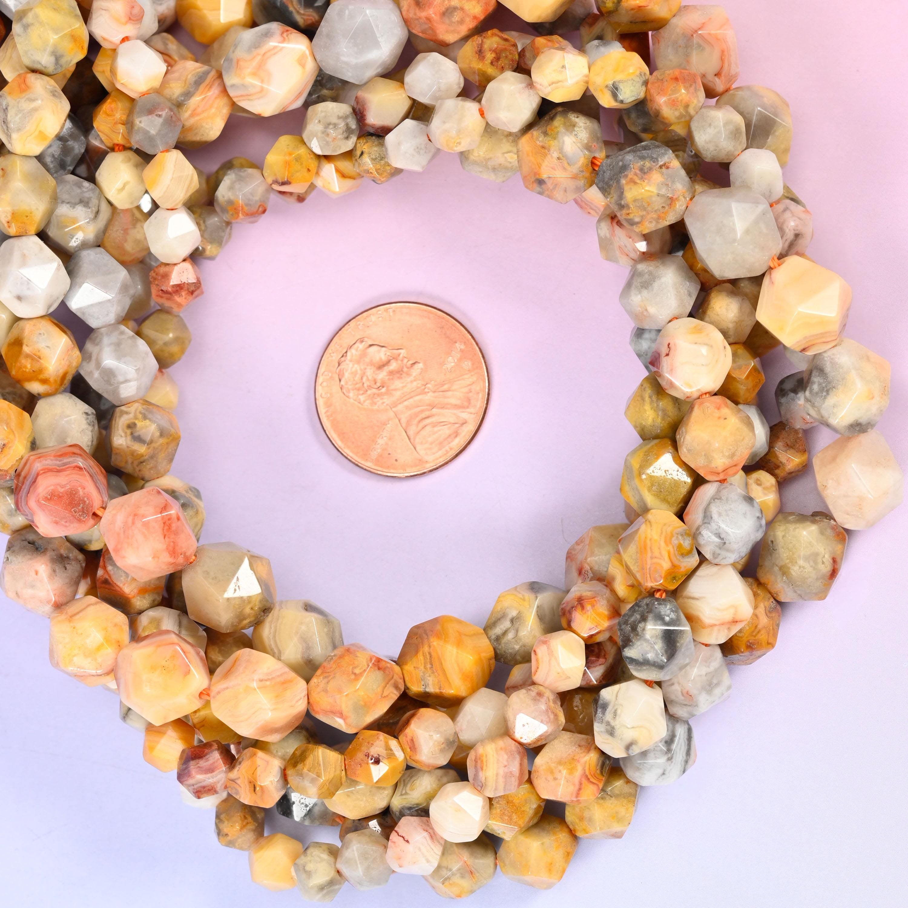 Crazy agate faceted diamond star cut bead strands coiled around a US penny for size reference