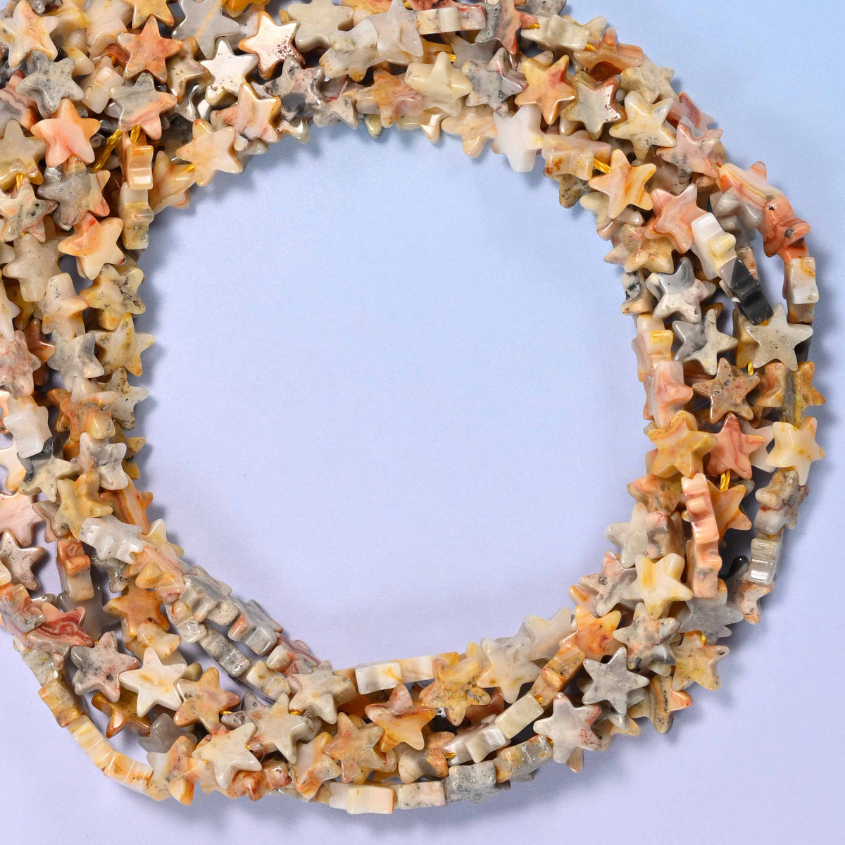 Crazy Agate flat star beads, close view of the coiled strands mixing cream, tan, grey and amber