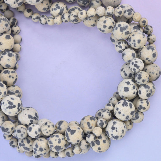 Dalmatian Jasper matte round beads, close view of the coiled strands showing cream with black spotting