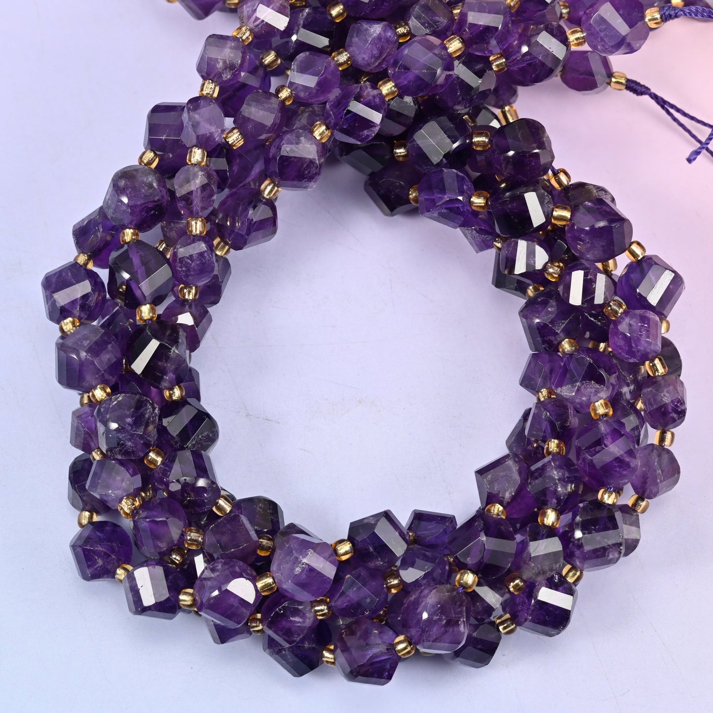 Dark Purple Amethyst faceted spiral twist beads, close view of the coiled strands in deep purple banded with clear stone