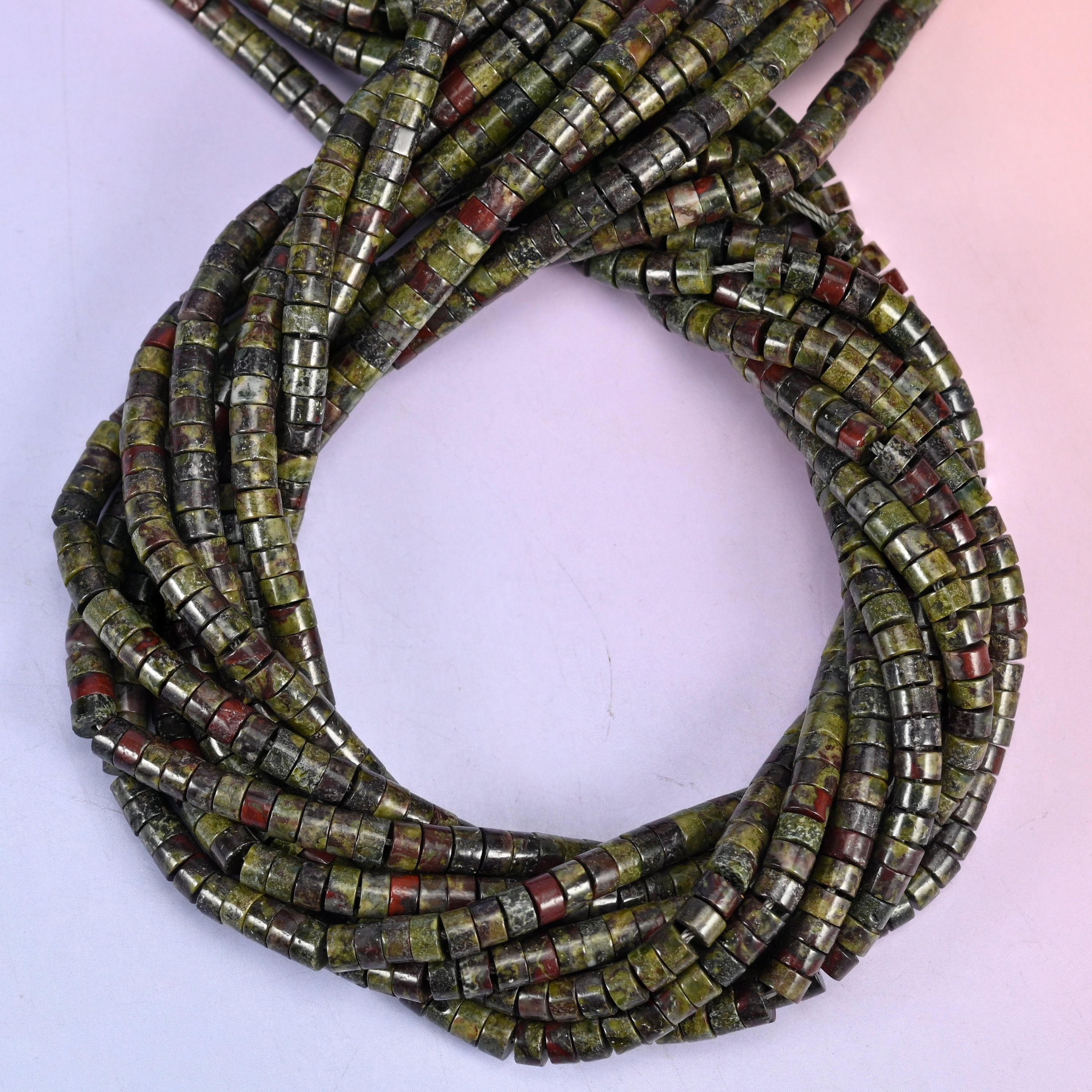 Dragon Blood Stone smooth heishi disc beads, close view of the coiled strands showing mottled green with red markings