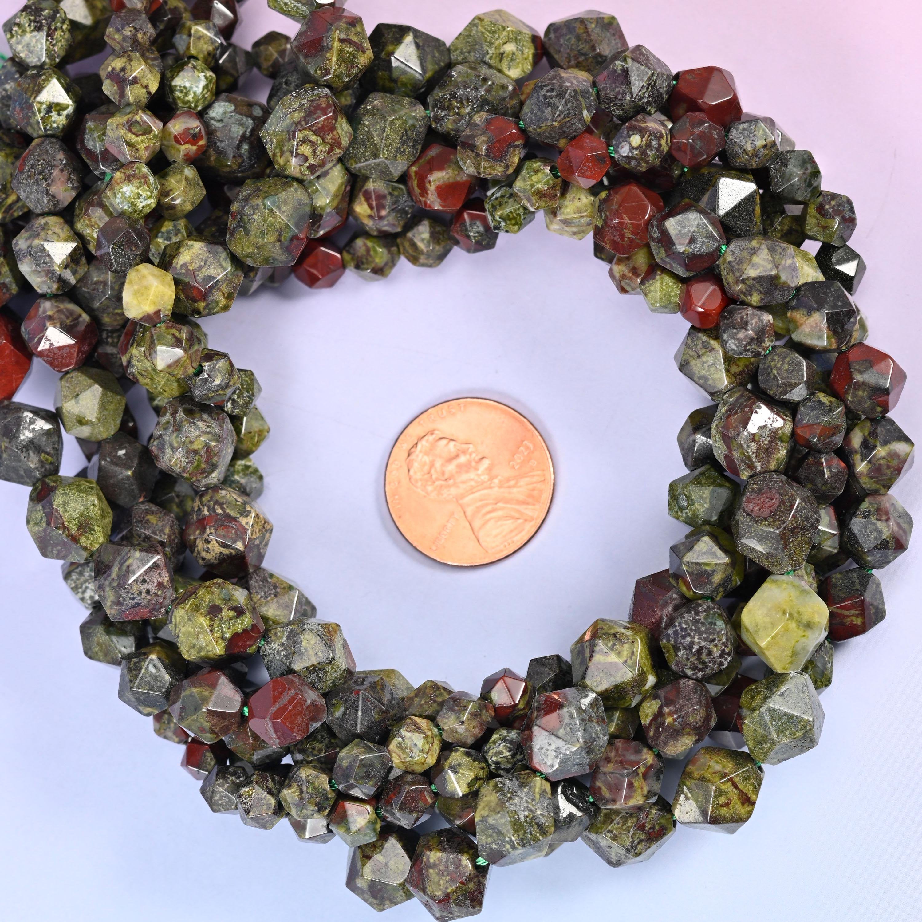Dragon bloodstone faceted diamond star cut bead strands coiled around a US penny for size reference