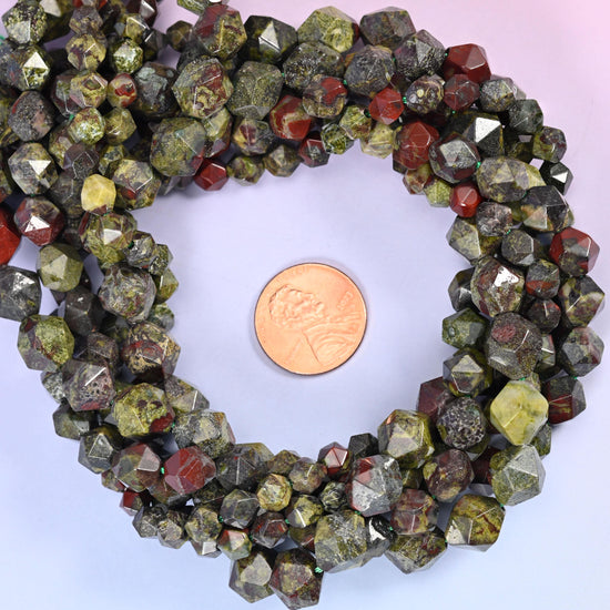 Dragon bloodstone faceted diamond star cut bead strands coiled around a US penny for size reference