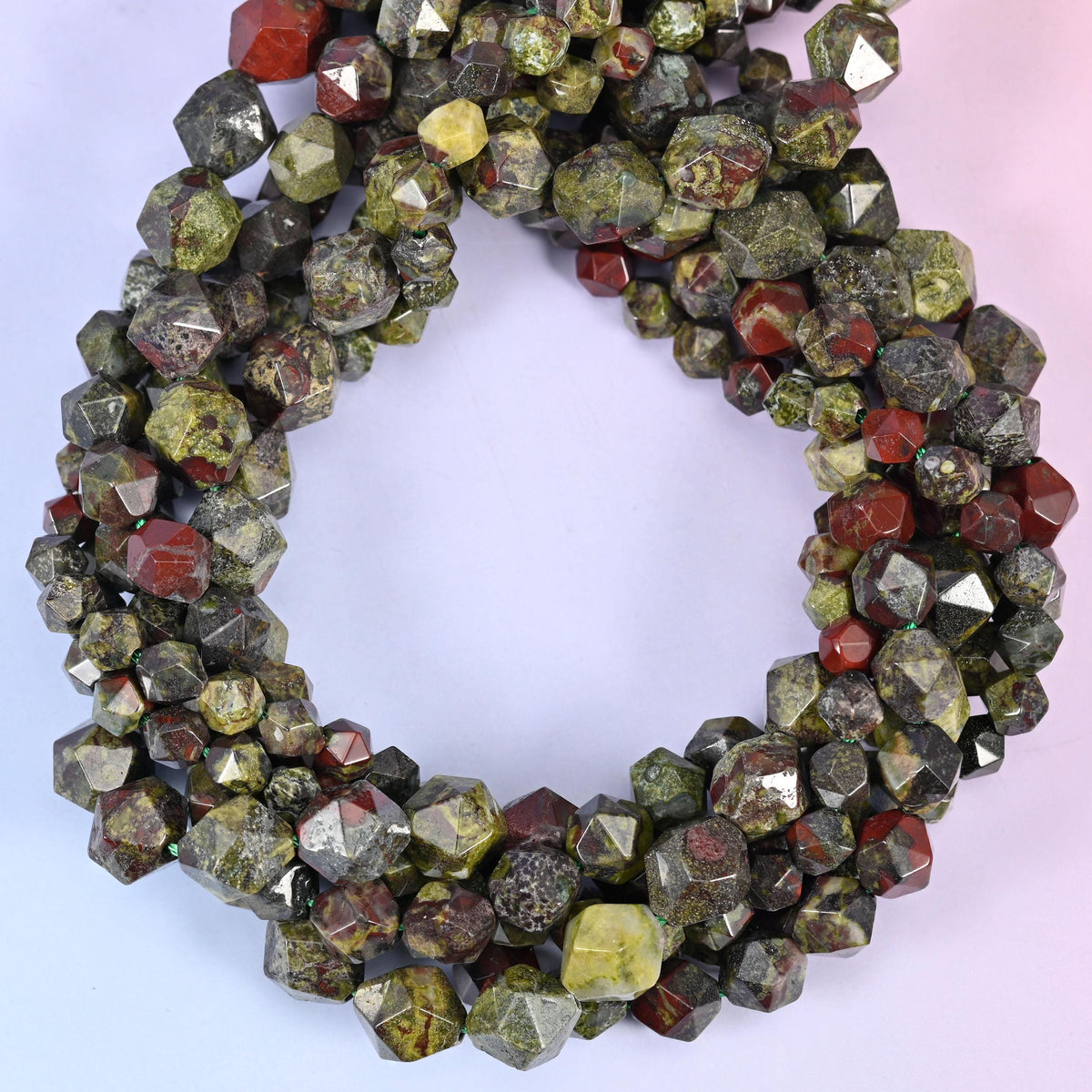 Dragon bloodstone faceted diamond star cut beads, strands coiled into a ring showing the mossy green stone with deep red patches