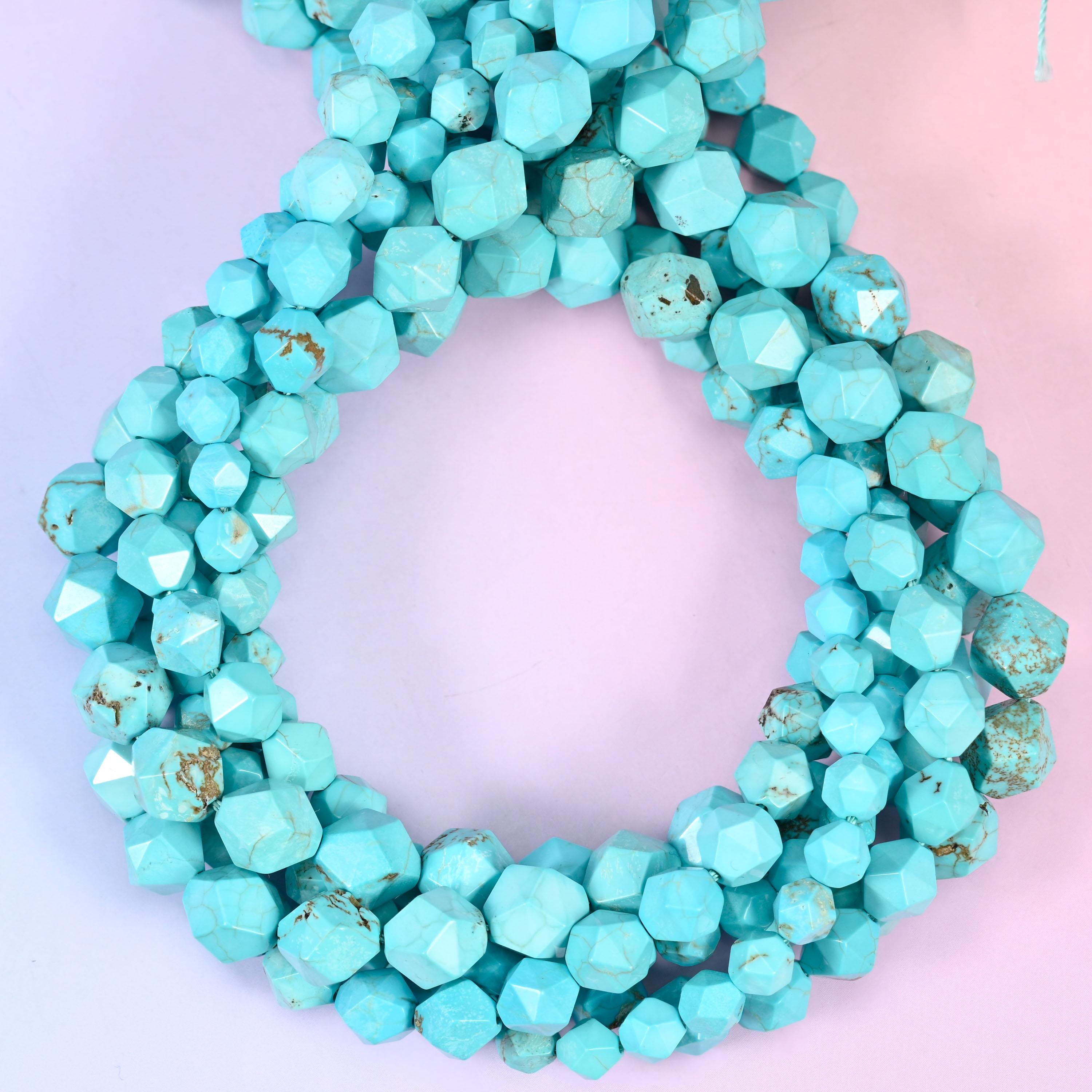 Dyed blue howlite faceted diamond star cut beads, strands coiled into a ring showing the even turquoise colour and fine grey veining