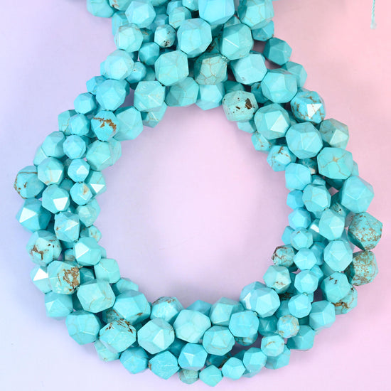 Dyed blue howlite faceted diamond star cut beads, strands coiled into a ring showing the even turquoise colour and fine grey veining