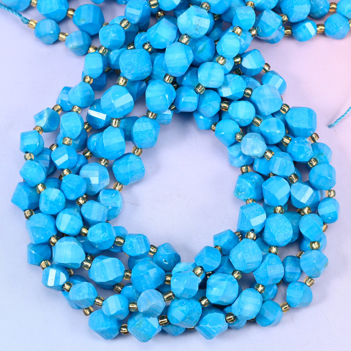 Dyed Blue Howlite faceted spiral twist beads, close view of the coiled strands showing the even bright blue colour