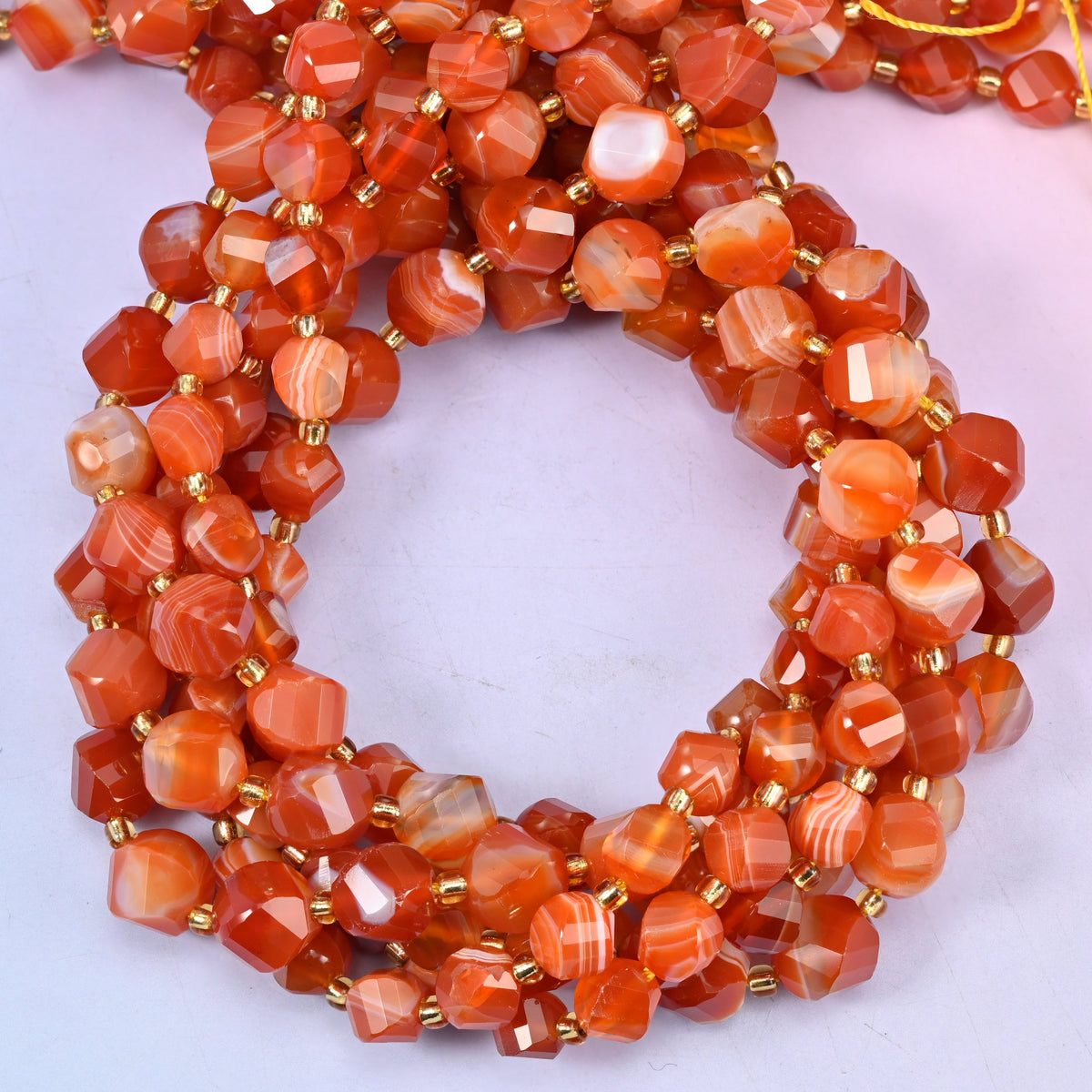 Dyed Red Stripe Agate faceted spiral twist beads, close view of the coiled strands in orange red with white banding