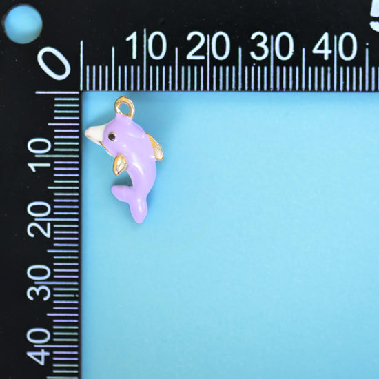 Single lilac enamel dolphin charm beside a millimetre ruler for scale