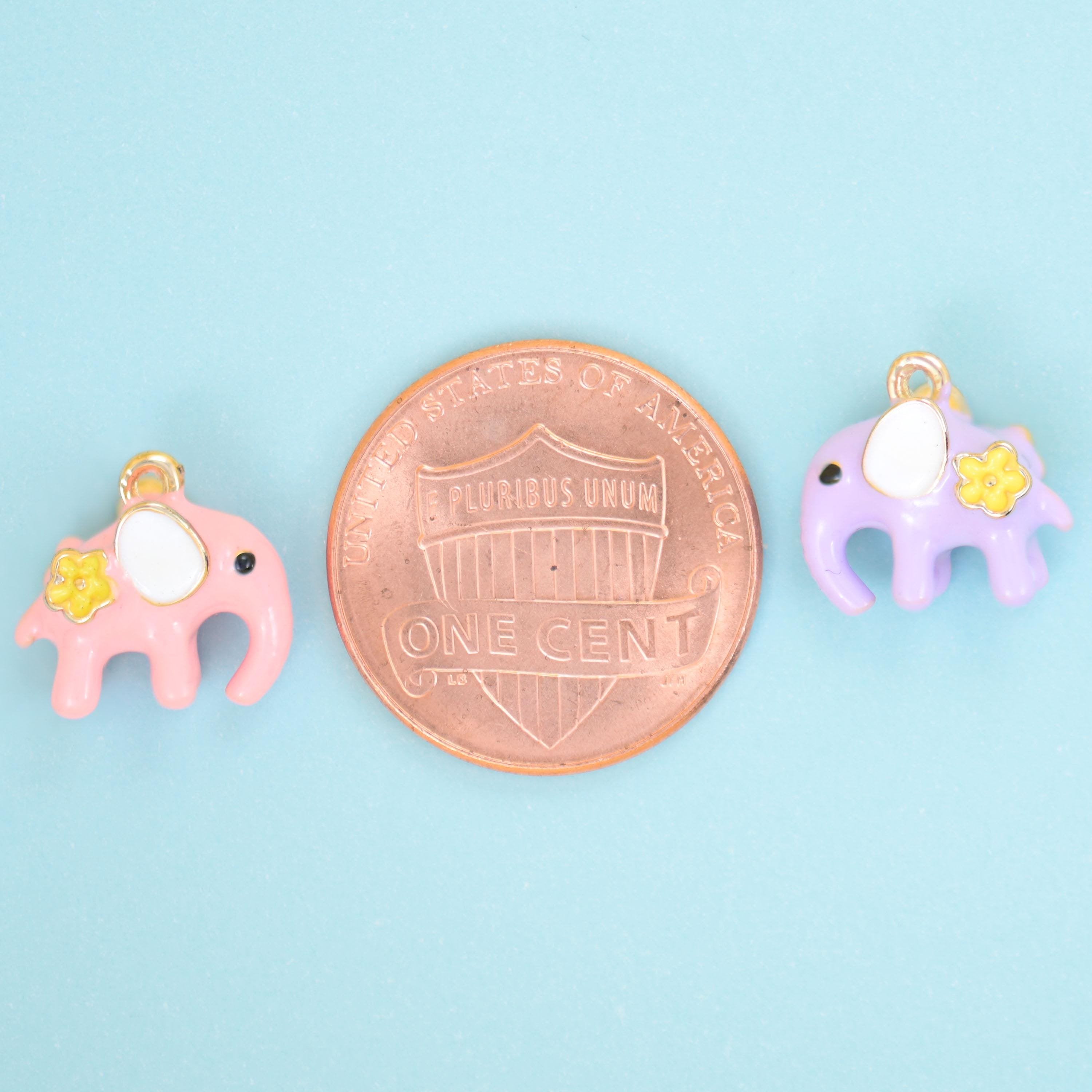 Pink and lilac enamel elephant charms shown either side of a US penny for size reference