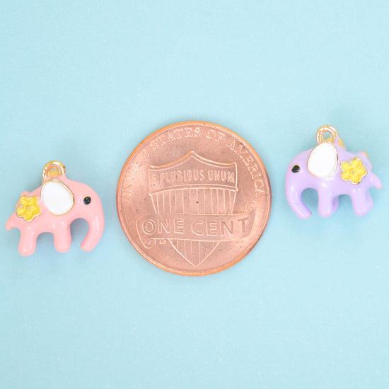 Pink and lilac enamel elephant charms shown either side of a US penny for size reference