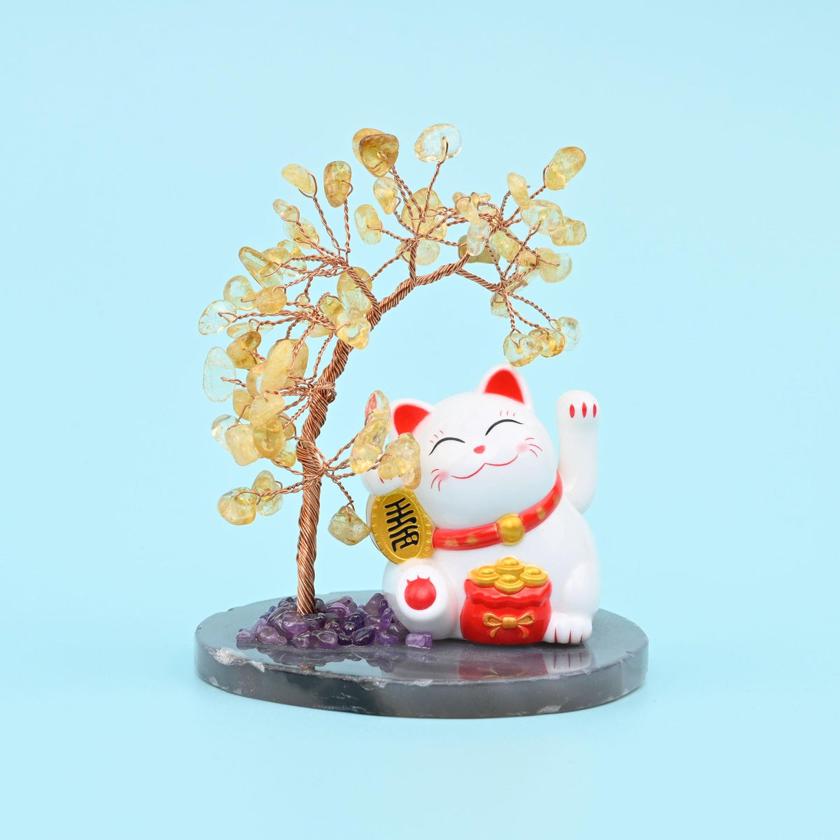 Gemstone tree with golden citrine chips beside a white waving fortune cat on a chip-set base