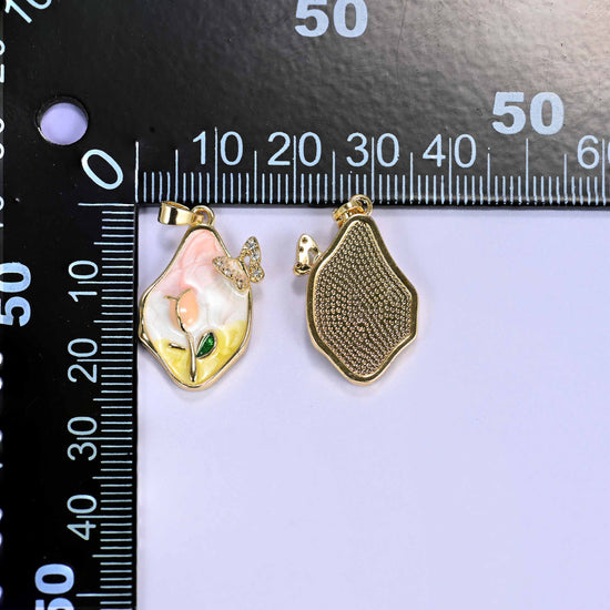 A freeform tulip butterfly charm shown front and back beside a millimetre ruler for scale