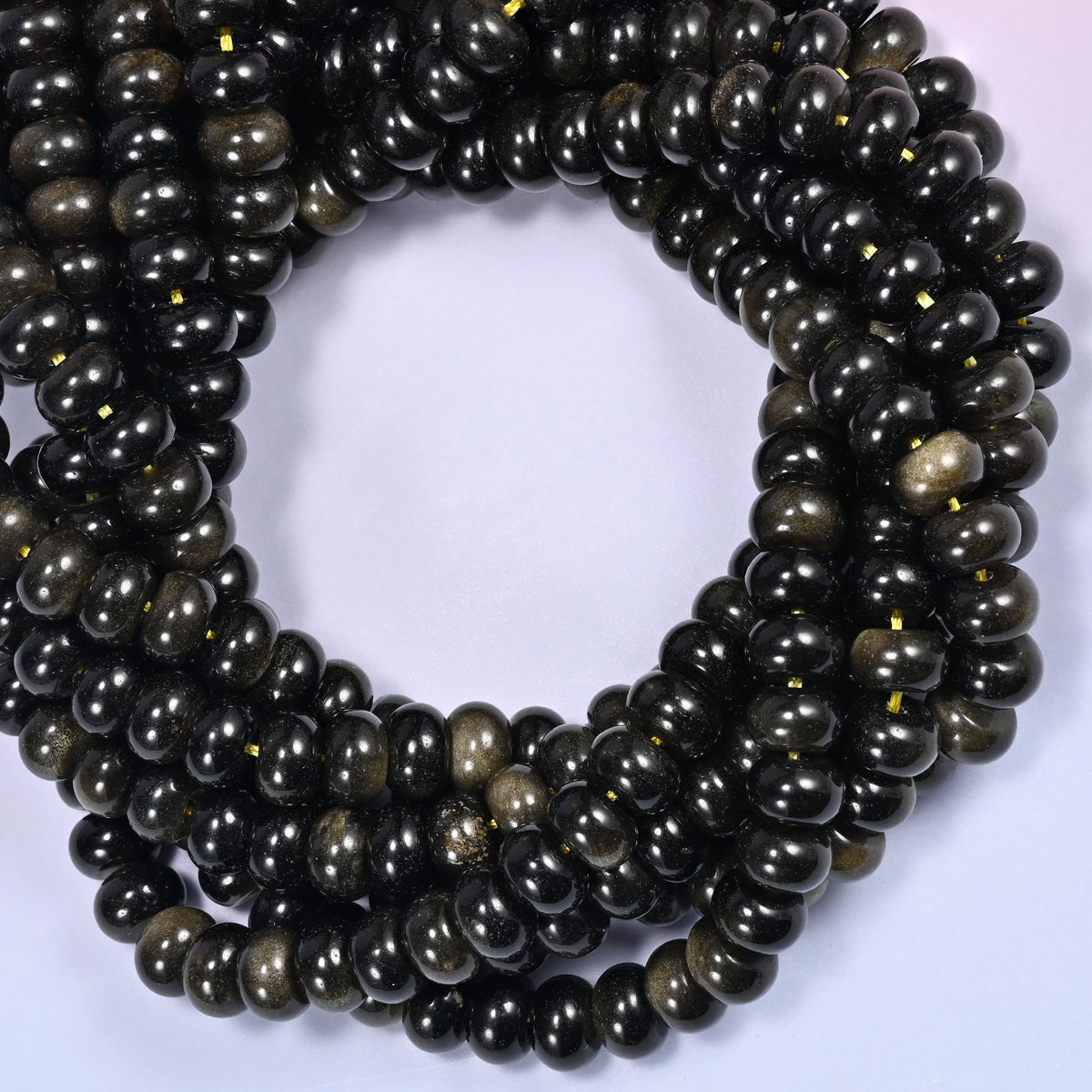 Gold Obsidian rondelle beads, close view of the coiled strands showing black with golden sheen