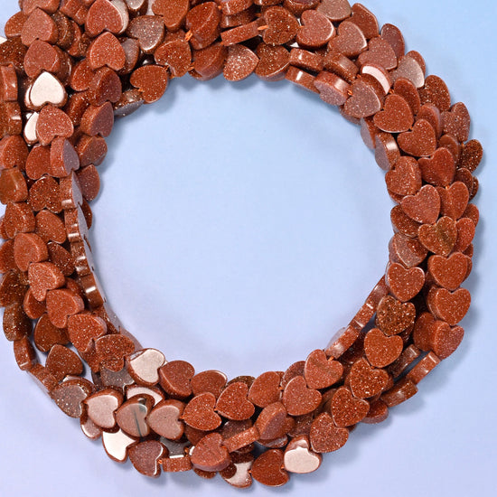 Gold Sandstone flat heart beads, close view of the coiled strands in coppery brown flecked with glitter