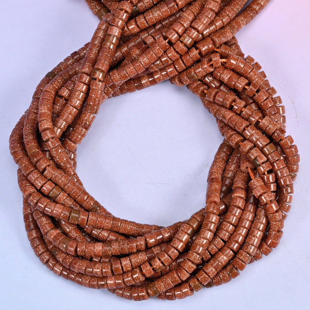 Gold Sandstone smooth heishi disc beads, close view of the coiled strands showing the copper-brown colour with fine glittering flecks
