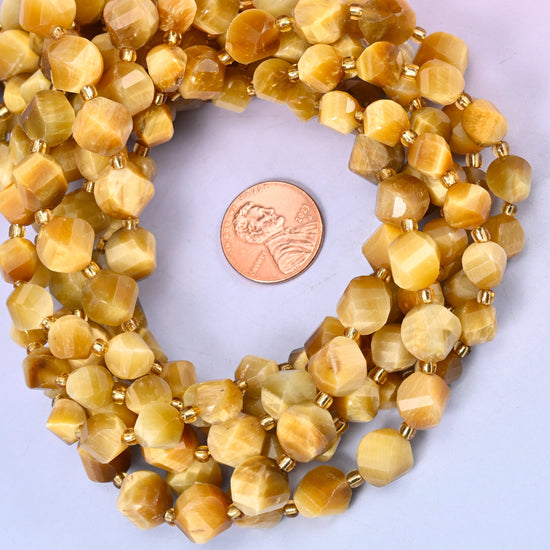 Gold Tiger Eye faceted spiral twist bead strands coiled around a US penny for size reference
