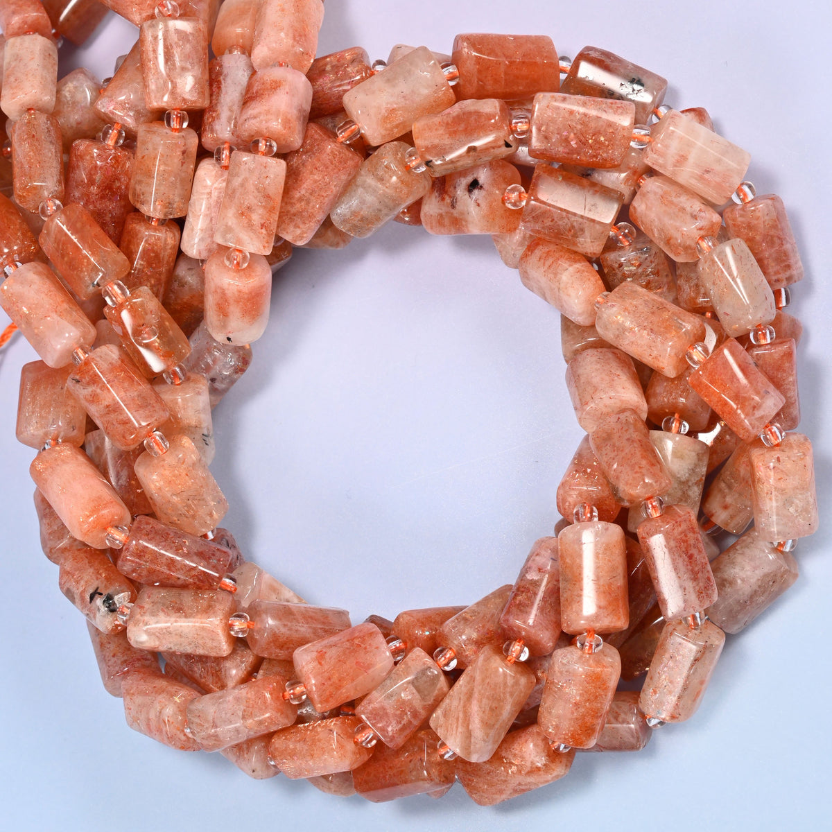 Golden strawberry quartz faceted tube beads, close view of the coiled strands in peach and orange