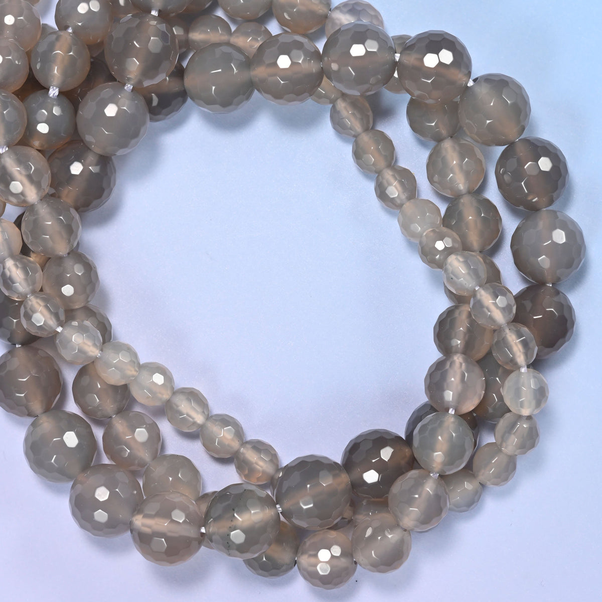 Gray Agate faceted round beads, close view of the coiled strands showing smoky grey and cream