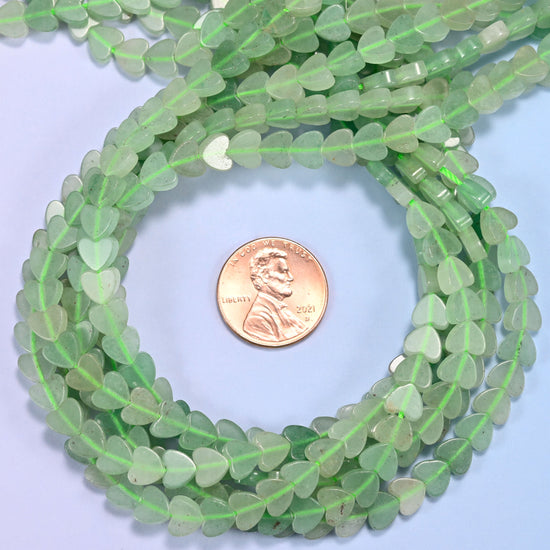 Green Aventurine flat heart bead strands coiled around a US penny for size reference