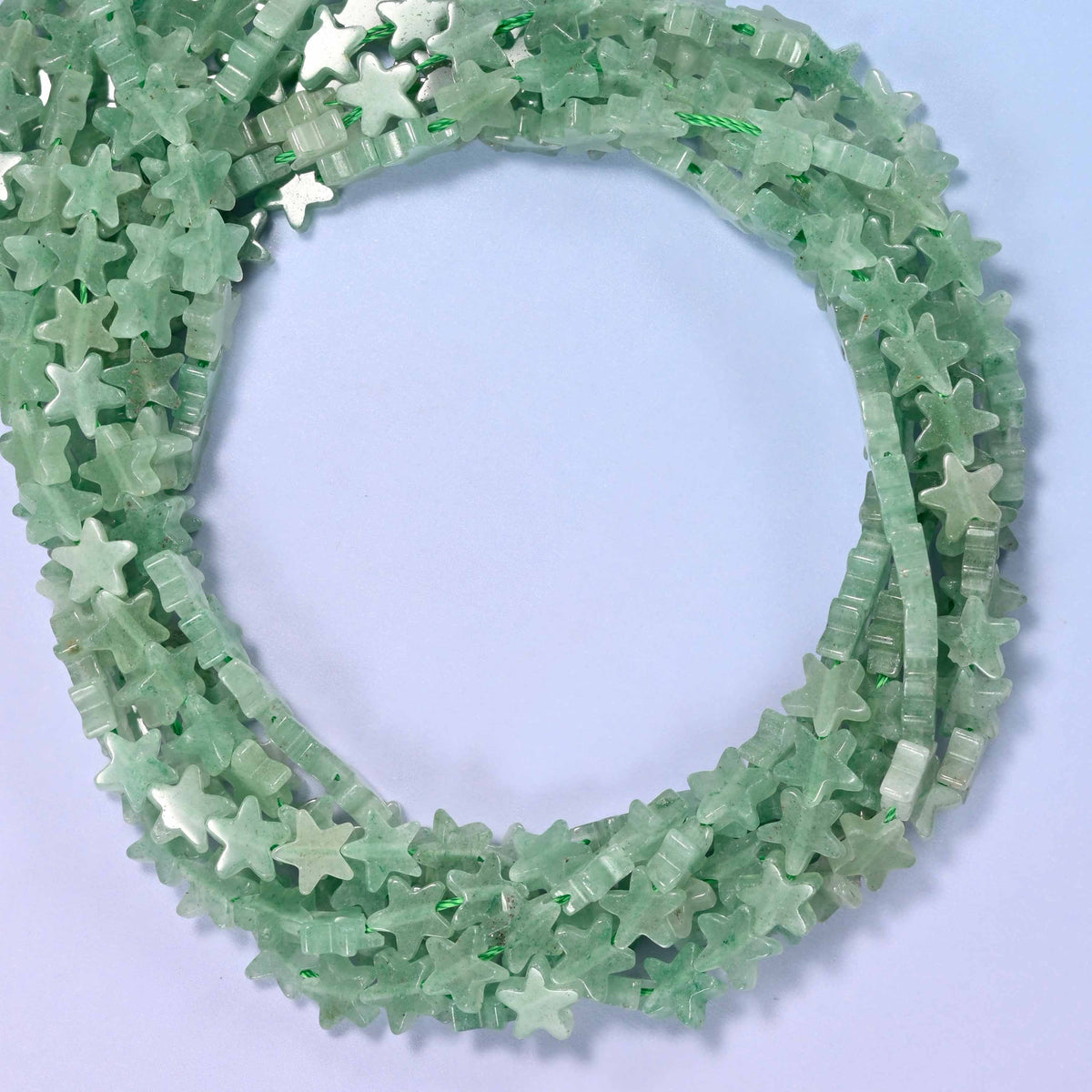 Green Aventurine flat star beads, close view of the coiled strands in soft green