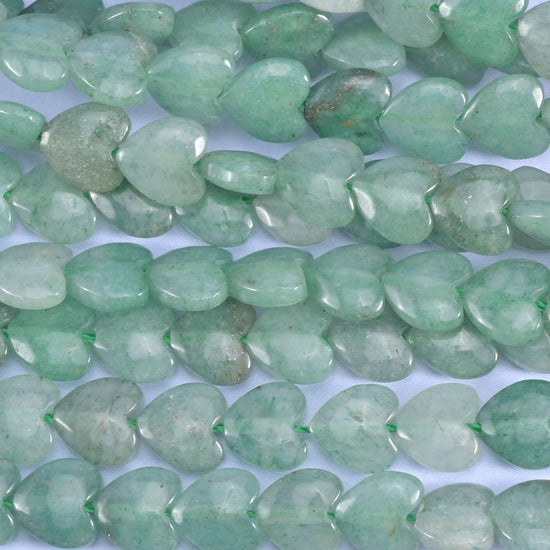Green aventurine heart beads, close view of several strands showing the puffed heart shape.