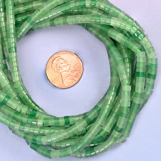 Green Aventurine smooth heishi disc bead strands coiled around a US penny for size reference