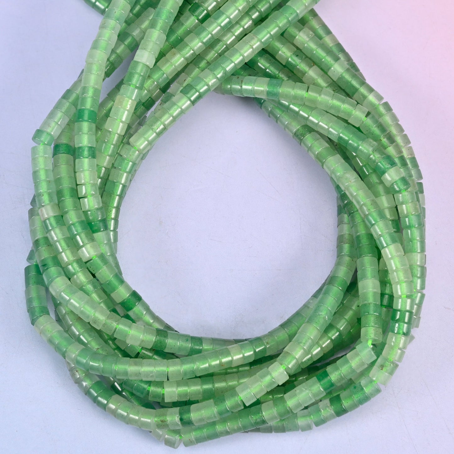 Green Aventurine smooth heishi disc beads, close view of the coiled strands showing the even green colour