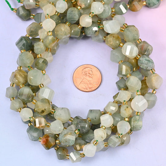 Green Grass Silk Stone faceted spiral twist bead strands coiled around a US penny for size reference