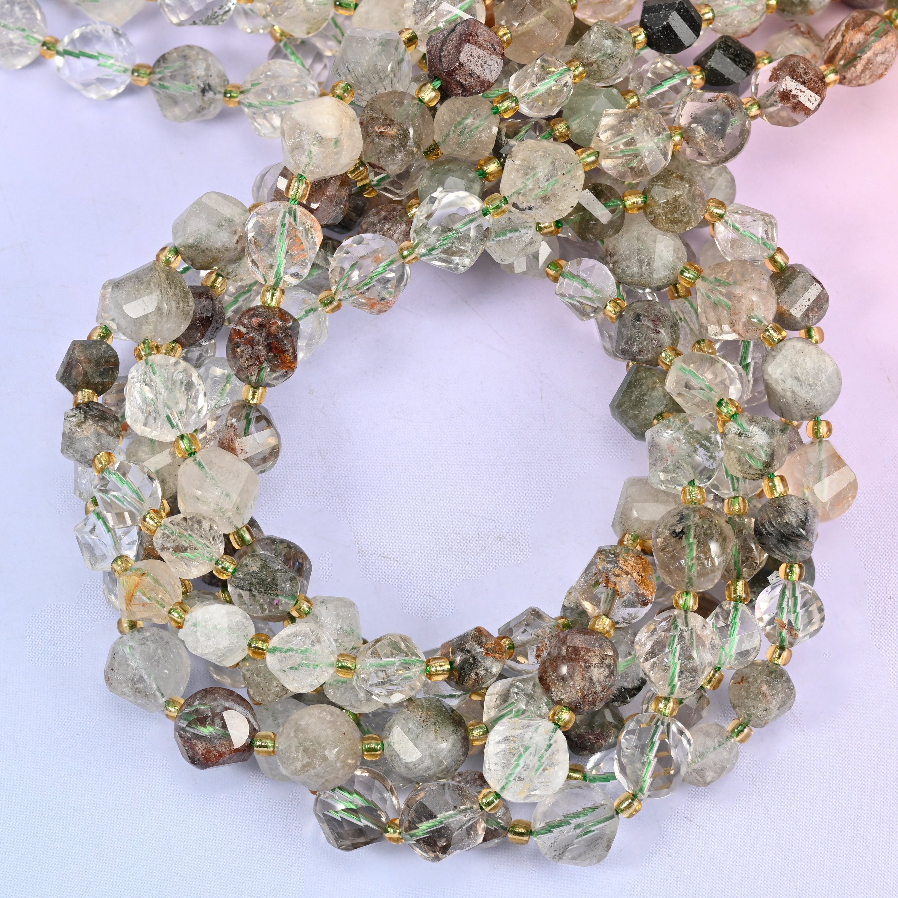 Green Phantom Quartz faceted spiral twist beads, close view of the coiled strands in soft green and clear stone with brown-green inclusions