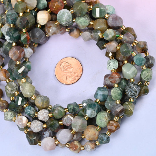 Indian Agate faceted spiral twist bead strands coiled around a US penny for size reference