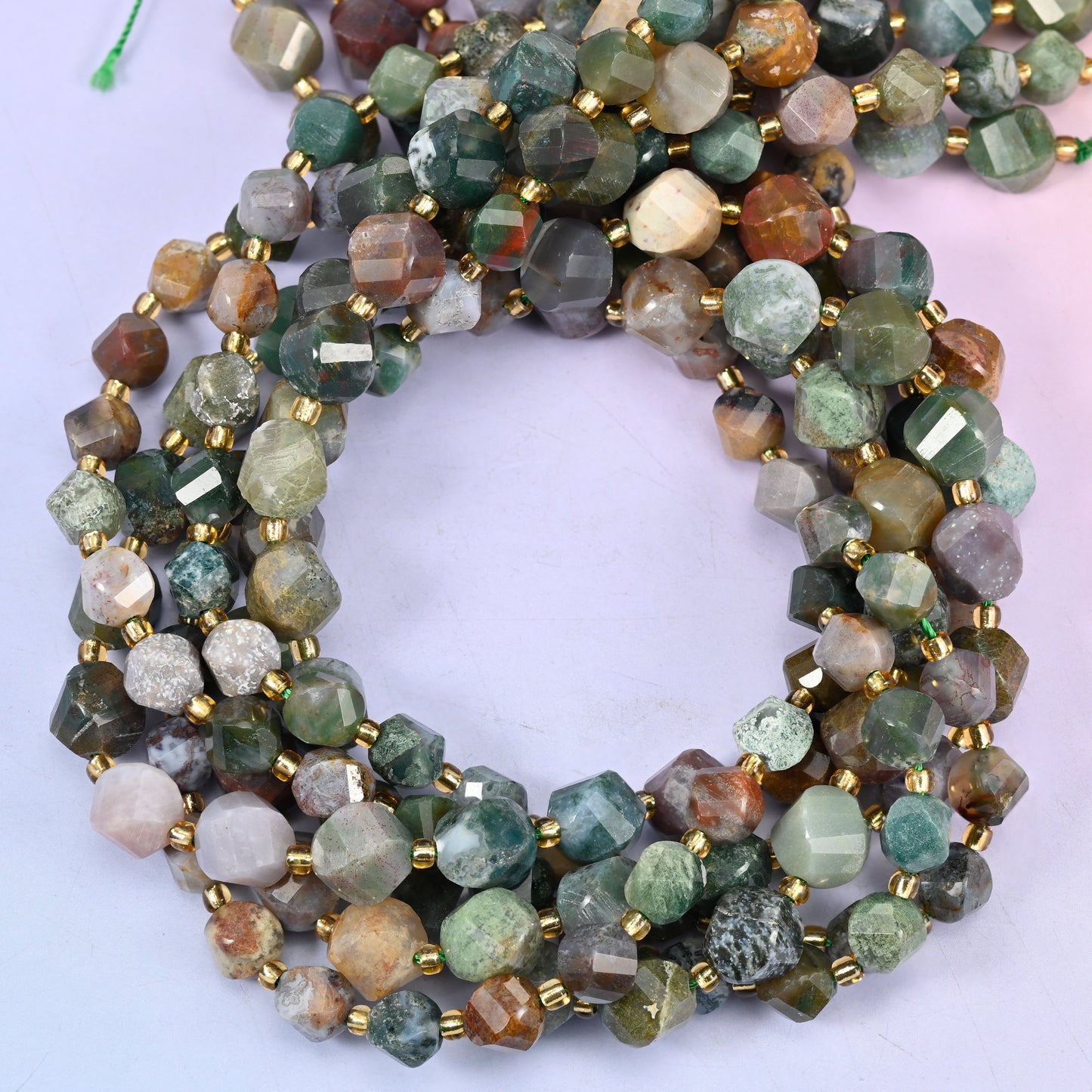 Indian Agate faceted spiral twist beads, close view of the coiled strands mixing green, cream, rust and grey