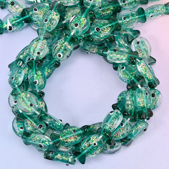 Iridescent Green Fish glass beads, close view of the coiled strands in deep green with gold glitter inclusions