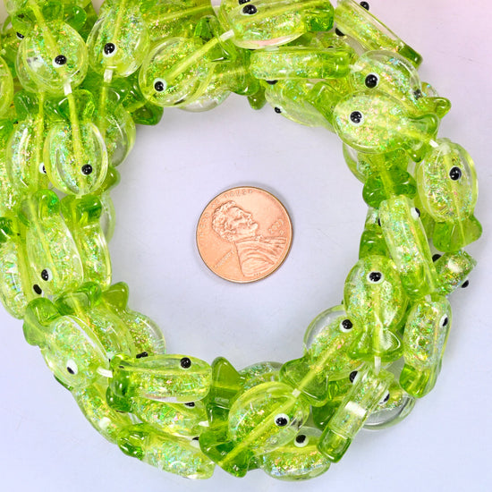 Iridescent Lime Green Fish glass bead strands coiled around a US penny for size reference