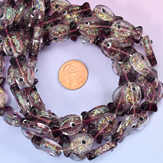 Iridescent Purple Fish glass bead strands coiled around a US penny for size reference