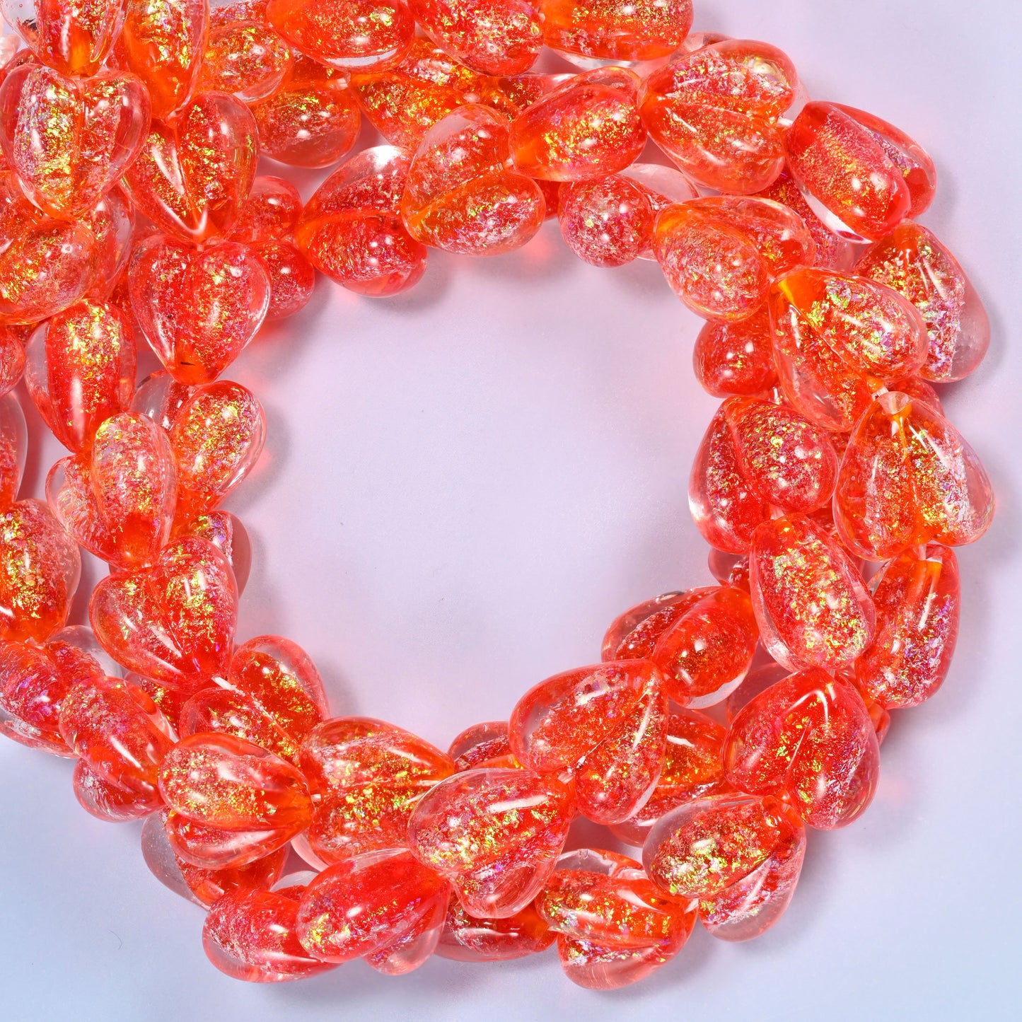 Iridescent Red Heart glass beads, close view of the coiled strands in orange red with gold glitter inclusions