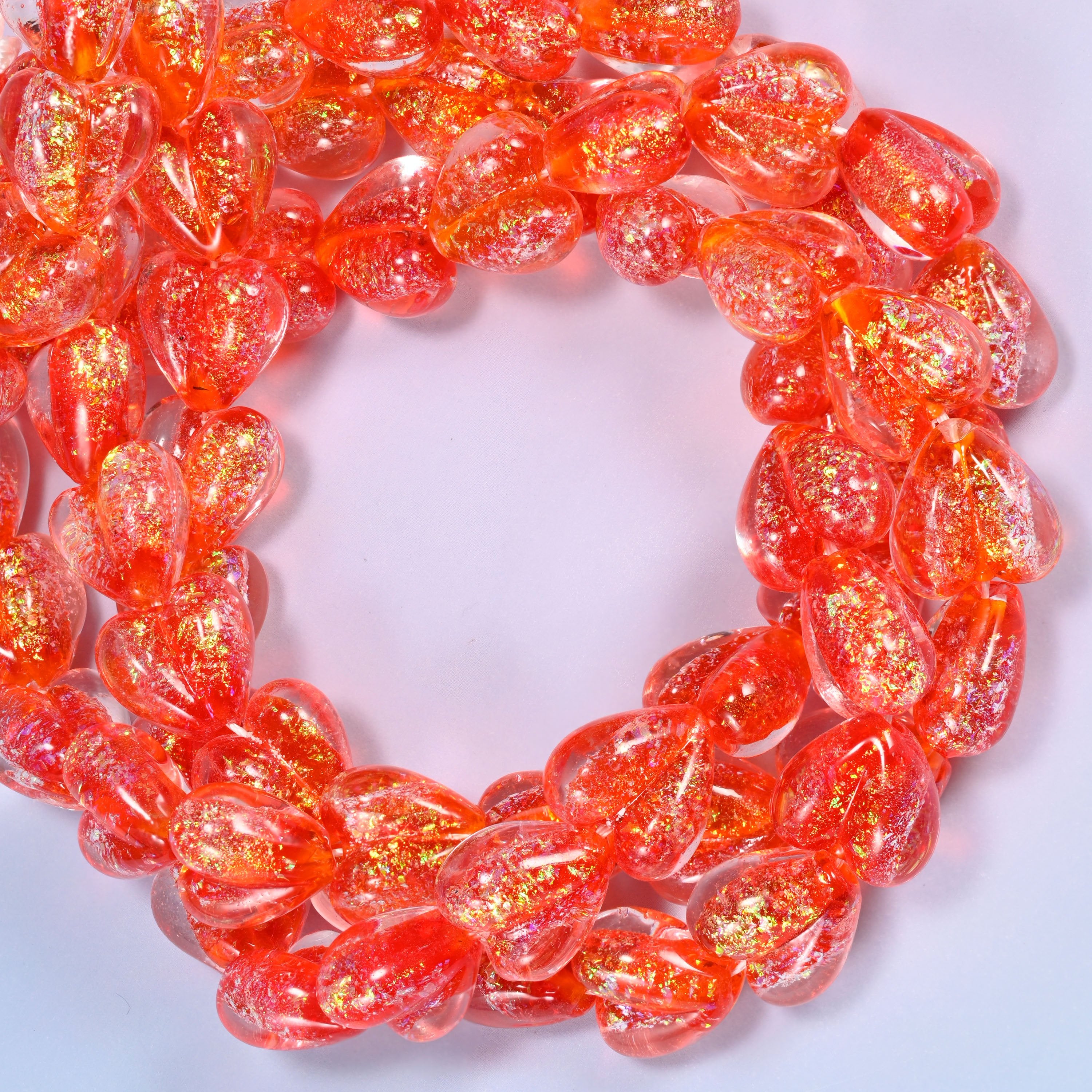 Iridescent Red Heart glass beads, close view of the coiled strands in orange red with gold glitter inclusions
